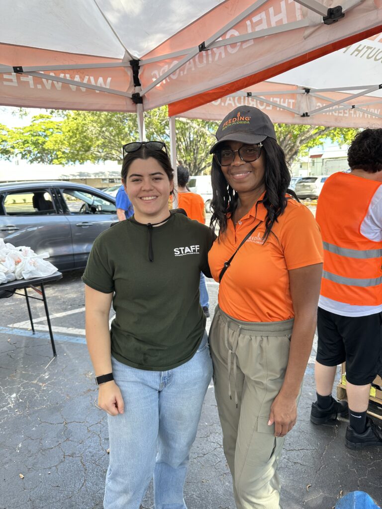 Community members gathering at Nina’s Place to receive Thanksgiving meals with support from local organizations.